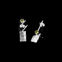 Discordant earrings by Rouaida on black background.