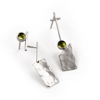 Discordant earrings by Rouaida on white background.