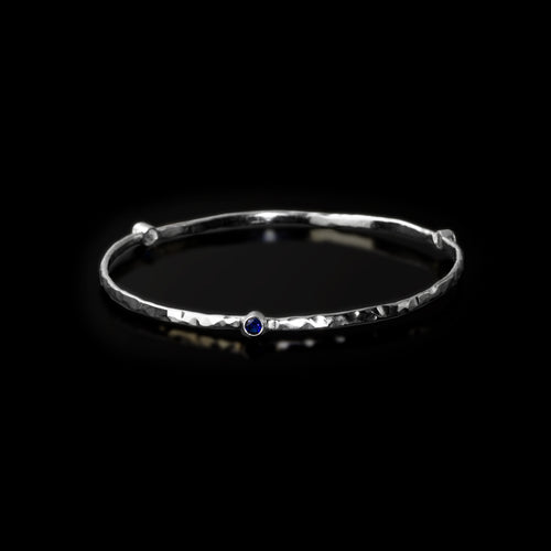 Silver Trinity bangle by Rouaida with red rubies or blue sapphires.